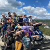 Eine Wandergruppe aus jungen Menschen auf dem Gipfel